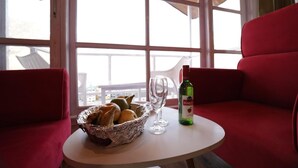 Un área de comedor con una mesa, una cesta de pan, dos copas de vino y una botella de Hawker's wine.