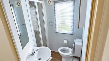 Une petite salle de bain comprenant un lavabo, des toilettes et une fenêtre.