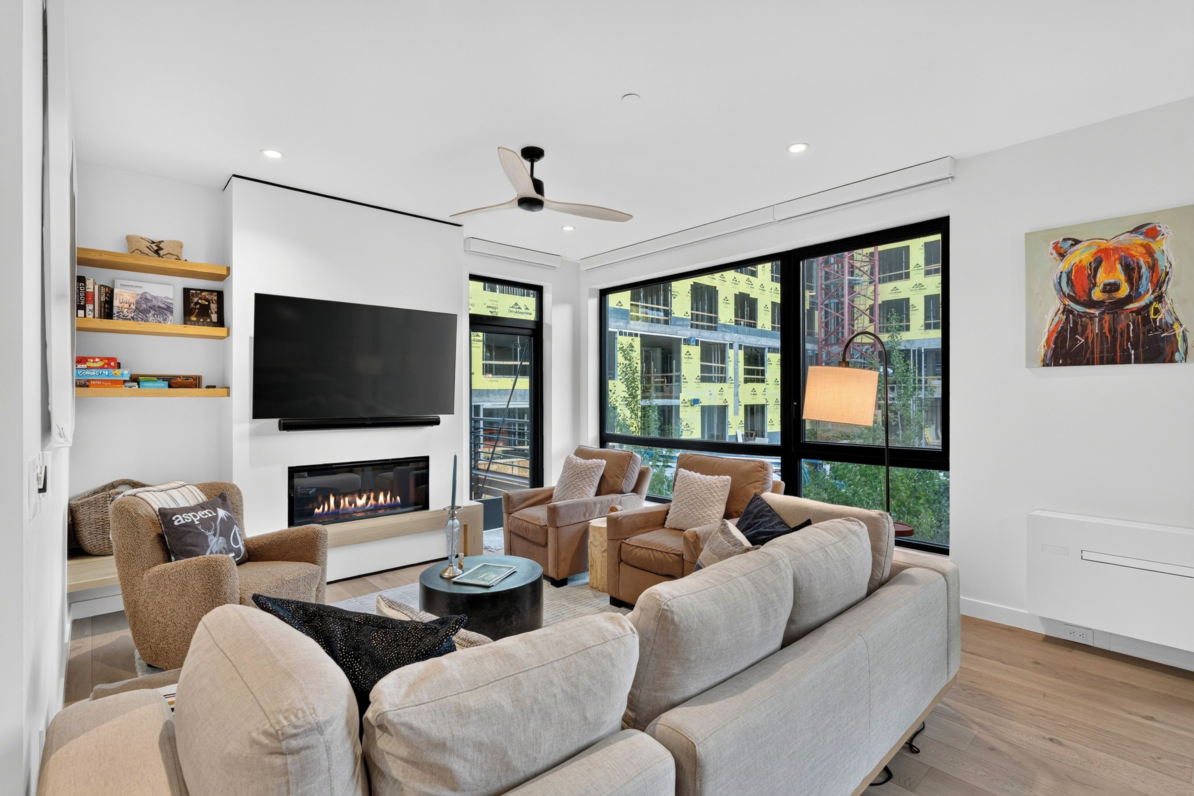 Spacious second-floor open layout living room featuring sleek, Opti-Myst fireplace and panoramic windows.