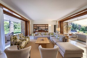 Ein großzügiger Wohnraum mit Ecksofa, Couchtisch und Bücherregal.