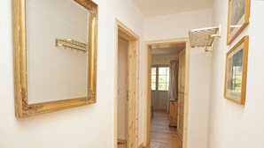 A hallway with a large ornate mirror, wooden doors, a basketball hoop, and a framed picture on the wall. - Surfer's Paradise Wiek - Lee Vacation Rental (Wiek)