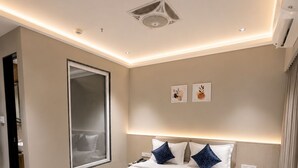 Una habitación de hotel moderna con una cama grande, una mesita de noche y un espejo amplio.