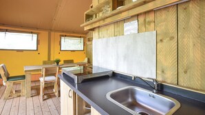 Cozinha compacta com pia, armários de madeira, bancada e janela.