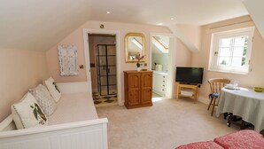 Ein Schlafzimmer mit Bett, Fernseher, Schreibtisch und Stuhl.