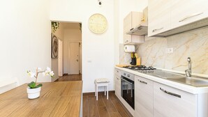 A modern kitchen with a marble countertop, a built-in oven, and a sink. - Appartamento Monteverde Casa Marí Roma (Roma)