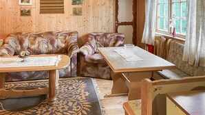 A cozy room with a wooden interior, a sofa, a table, and a window with curtains. - 4 bedroom lovely home in Nordfjordeid (Nordfjordeid)