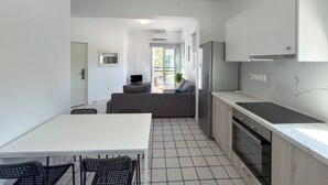 Una cocina moderna con armarios blancos, una encimera negra y un horno empotrado.