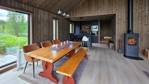 A wooden dining area with a long table, benches, and a view of the outdoors. - Gorgeous home in Torpo with WiFi (Torpo)