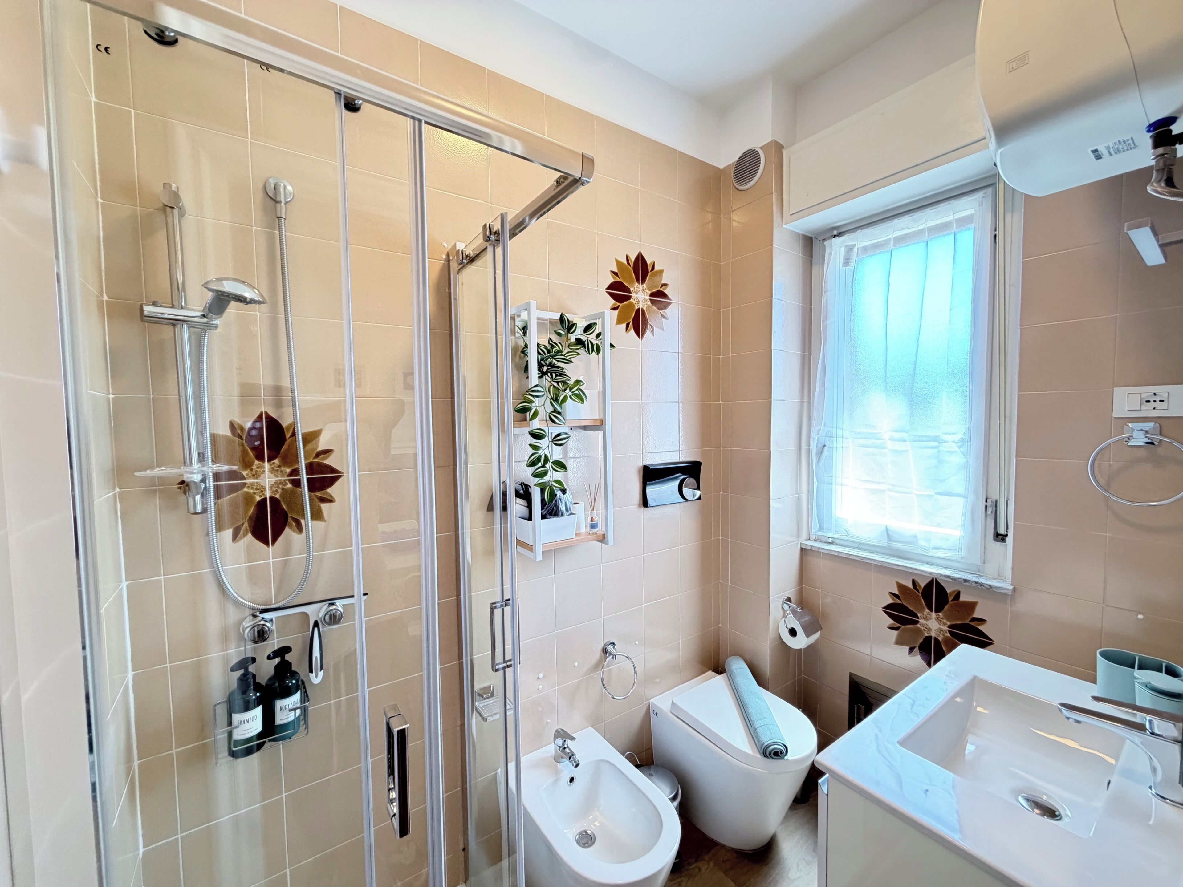 Ein modernes Badezimmer mit Duschkabine aus Glas, Toilette, Bidet und Waschbecken.