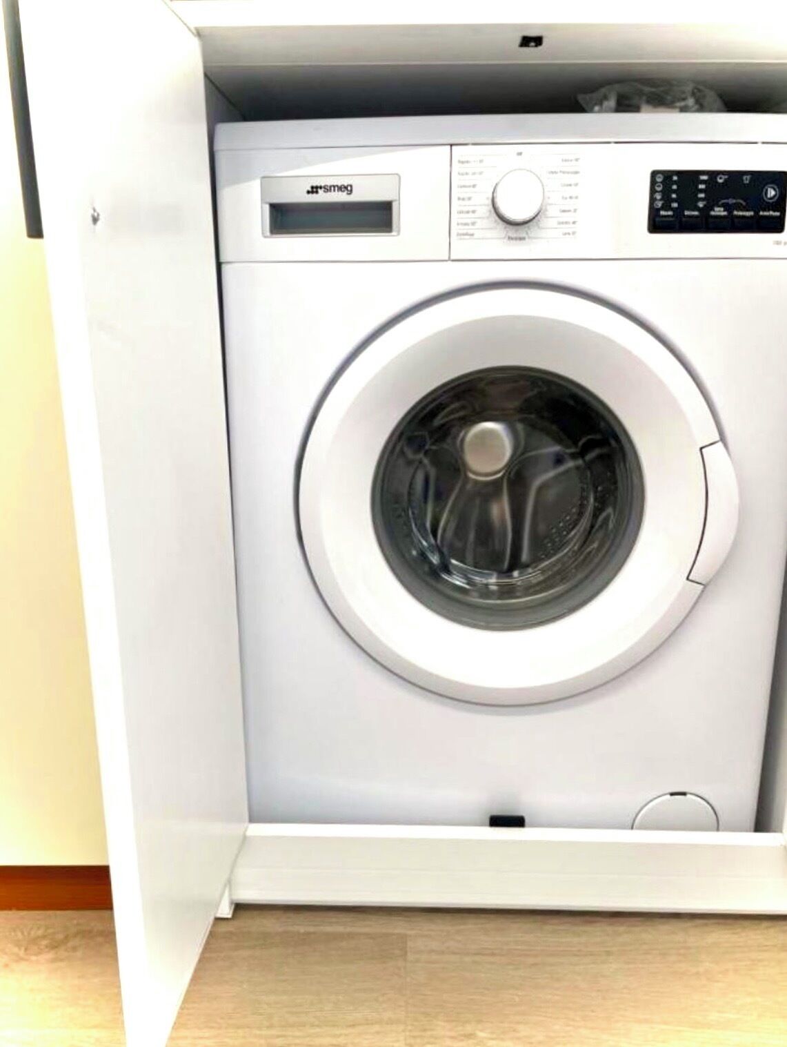Vue de face d’un lave-linge blanc, doté d’un panneau de commande et d’un écran numérique.
