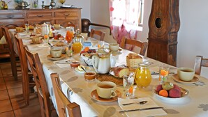 A breakfast table set with various dishes, including bread, fruit, and beverages. - Bed and Breakfast 'Chambre La Paille' with Mountain View, Shared Pool and Wi-Fi (Castelnau-Pégayrols)