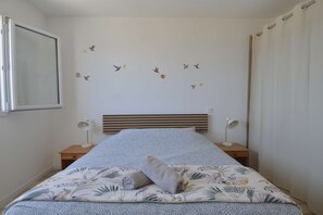 A bedroom with a bed, two bedside tables, a headboard, and wall decals of birds and flowers. - L'Horizon, breathtaking view, right next to a bunker (Saint-Côme-de-Fresné)