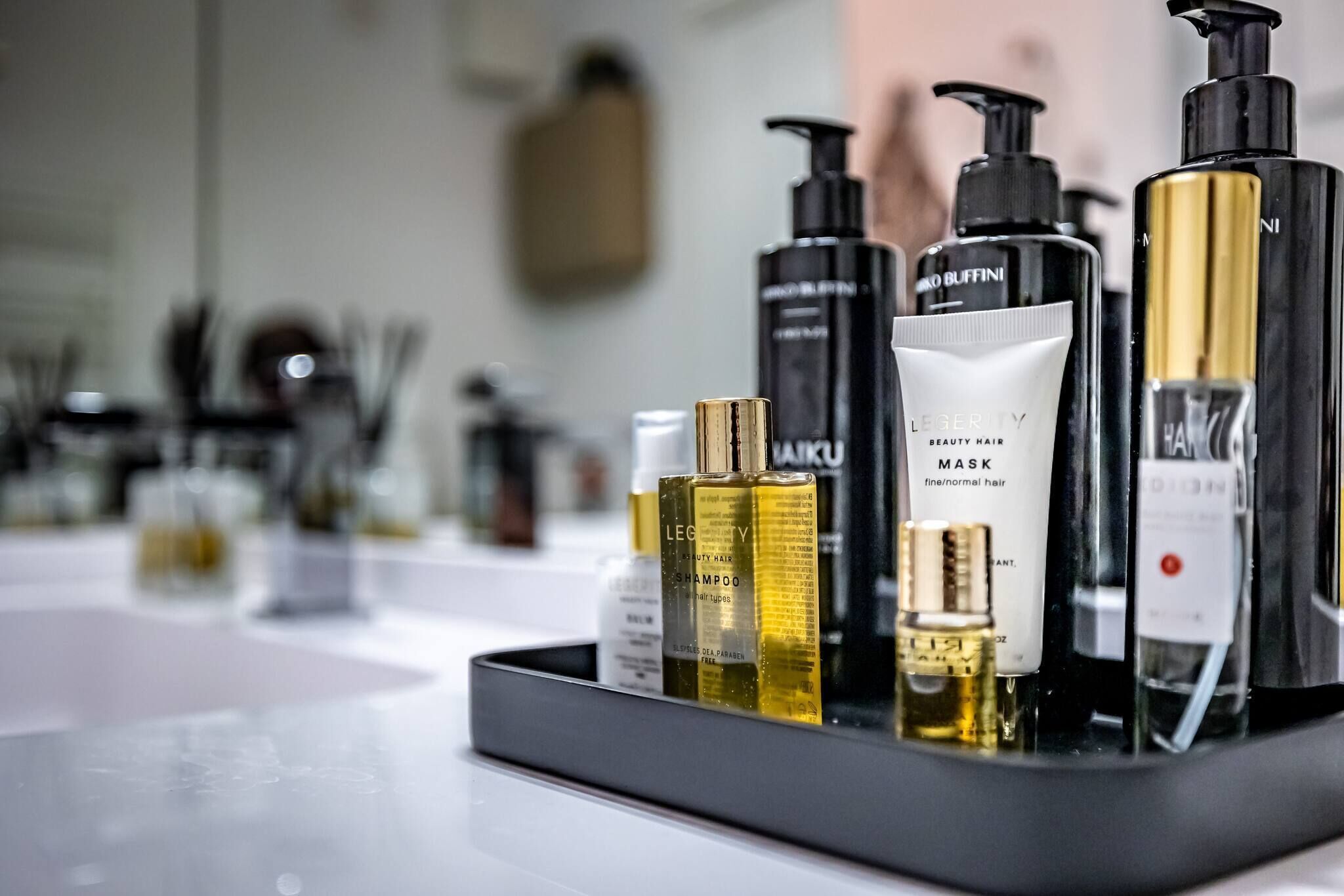 A variety of hair care products on a tray.
