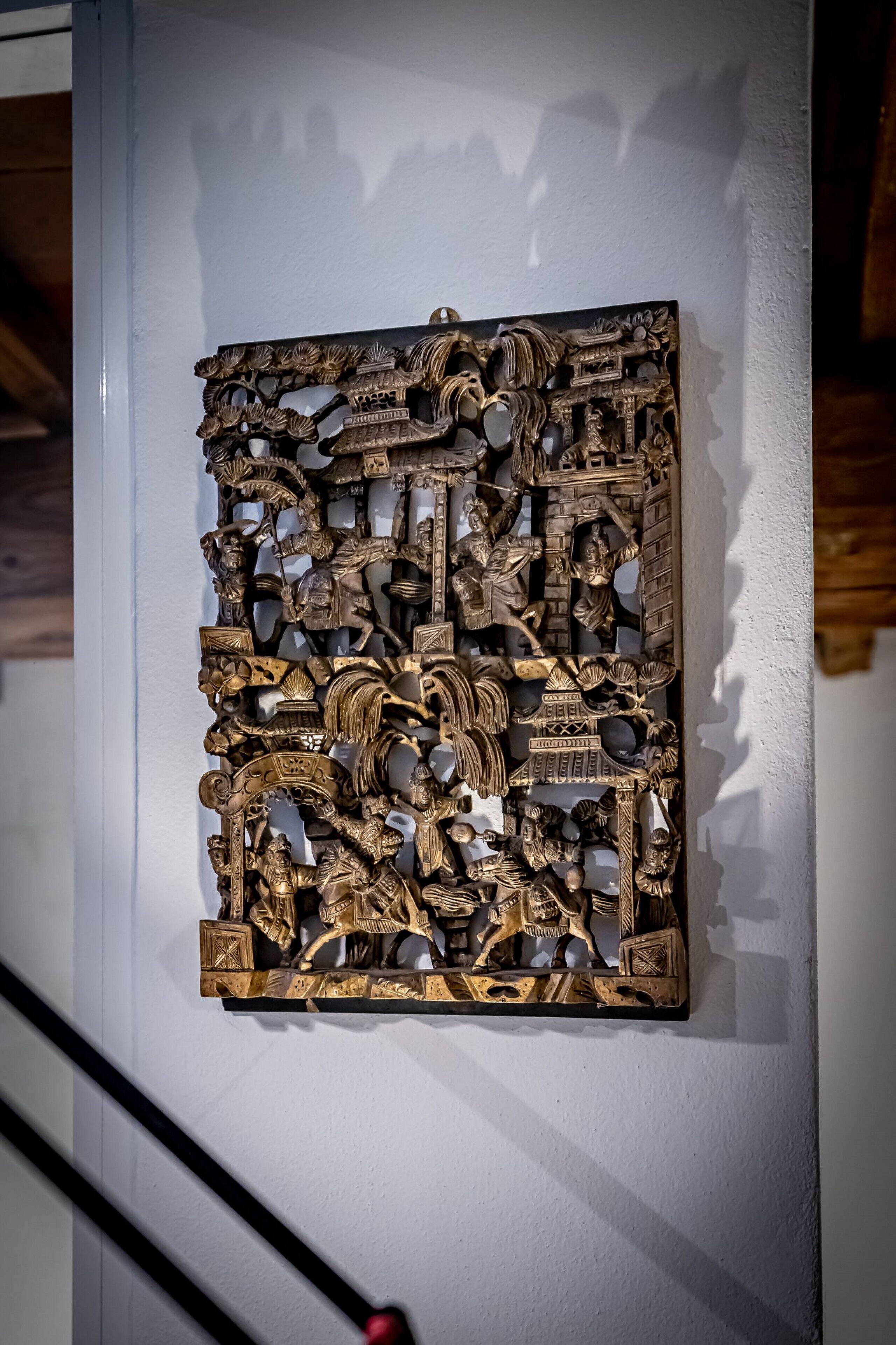 A detailed wall-mounted sculpture with intricate designs and figures.