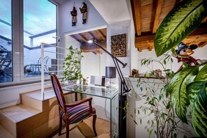 Ein modernes Interieur mit einem Glastisch, einem Holzstuhl, einer Treppe und einem großen Fenster.