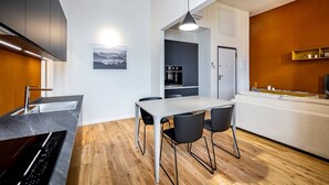 Una cocina moderna con comedor, suelo de madera y un amplio ventanal.
