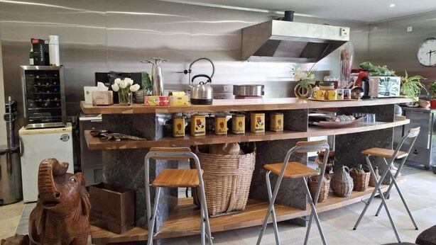Una cocina moderna con encimera de mármol, electrodomésticos de acero inoxidable y una isla de madera con taburetes de bar.
