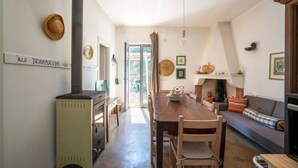Ein gemütliches Interieur mit einem Holztisch, einer Couch, einem Kamin und einem alten Herd.