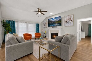A living room with a fireplace, two armchairs, a sofa, and a television. - Modern Mesquite Retreat  Patio + Smart TVs (Mesquite)