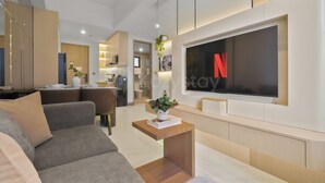 Una sala de estar moderna con un sofá, una mesa de centro y un televisor montado en la pared.