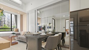 Una sala de estar moderna con comedor, ventanas amplias y vista a un edificio.