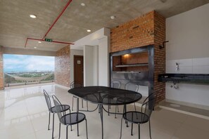 Una cocina moderna con pared de ladrillo, una mesa redonda grande con sillas y vistas a través de un ventanal.