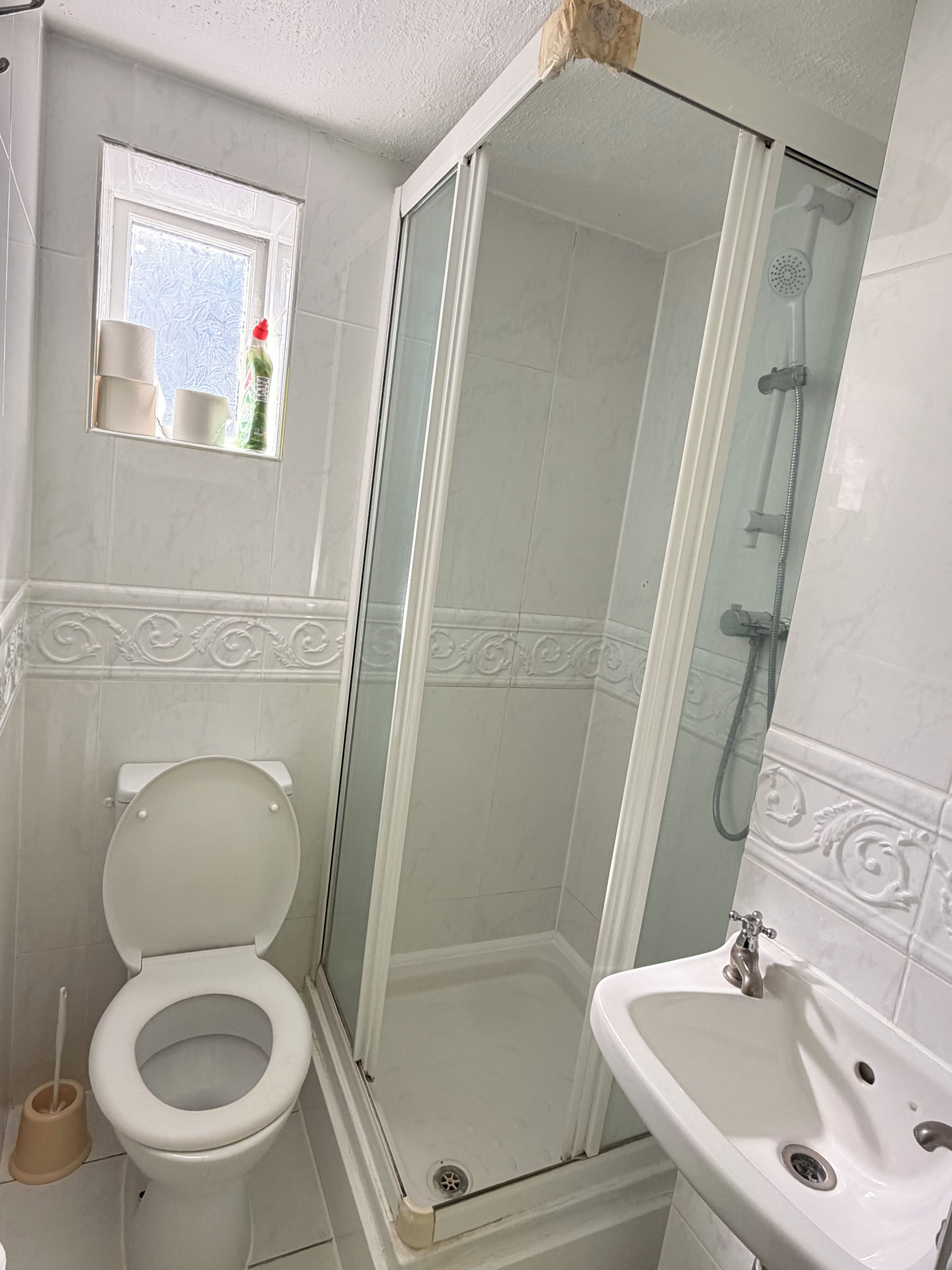 Ein Badezimmer mit Toilette, Duschkabine und Waschbecken.