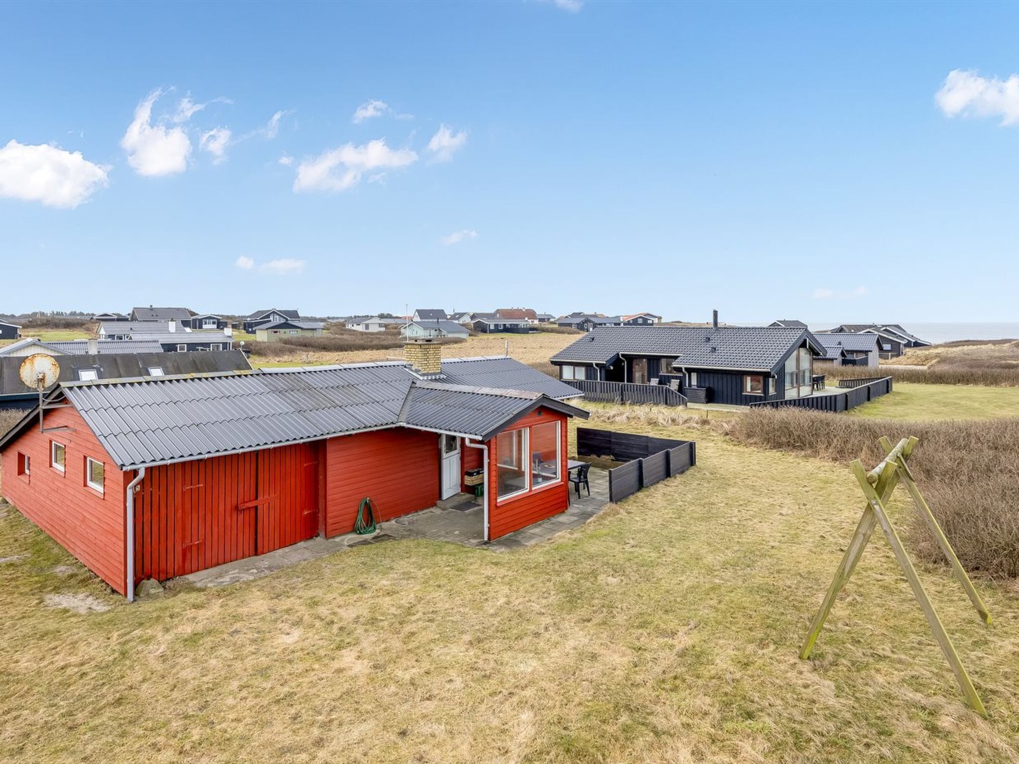 Una zona costera con varias casas de playa de techos planos, algunas con terrazas adosadas.