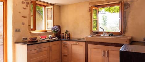 A kitchen with wooden cabinets, a countertop, and a window.