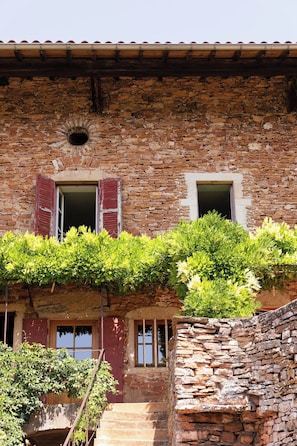 A rustic stone building with a wooden staircase leading to a door, and a small window with a wooden frame. - Maison Pourpre | Sleeps 10 | Burgundy | Close to the village (Leynes)