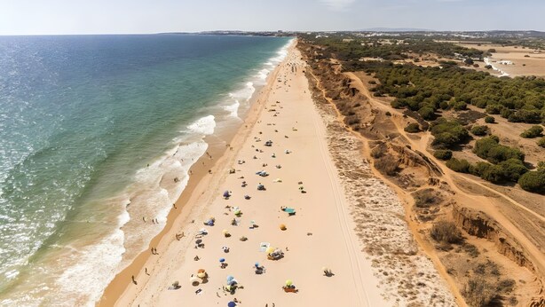 Una playa con gente, cielo despejado y una línea costera.