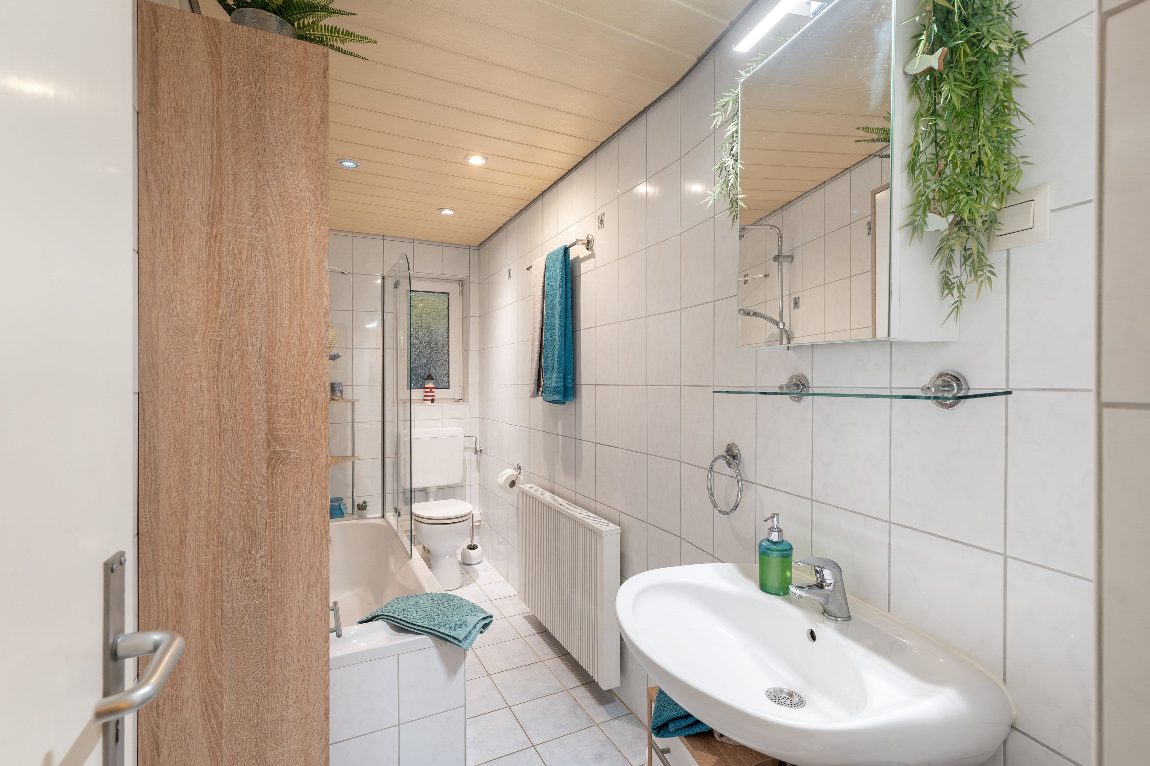 Une salle de bain moderne équipée d’une baignoire, de toilettes et d’un lavabo.