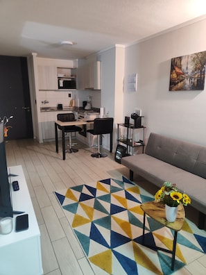 A modern apartment with a kitchen, dining area, and living room.