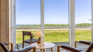 Een kamer met een groot raam en uitzicht op het strand en de oceaan.