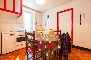 A kitchen with a dining table, chairs, a refrigerator, an oven, and a window. - Holiday Home 'Mas Le Manoulier, 14 Seats' with Mountain View, Private Pool and Private Terrace (Saint-Sauveur-de-Montagut)