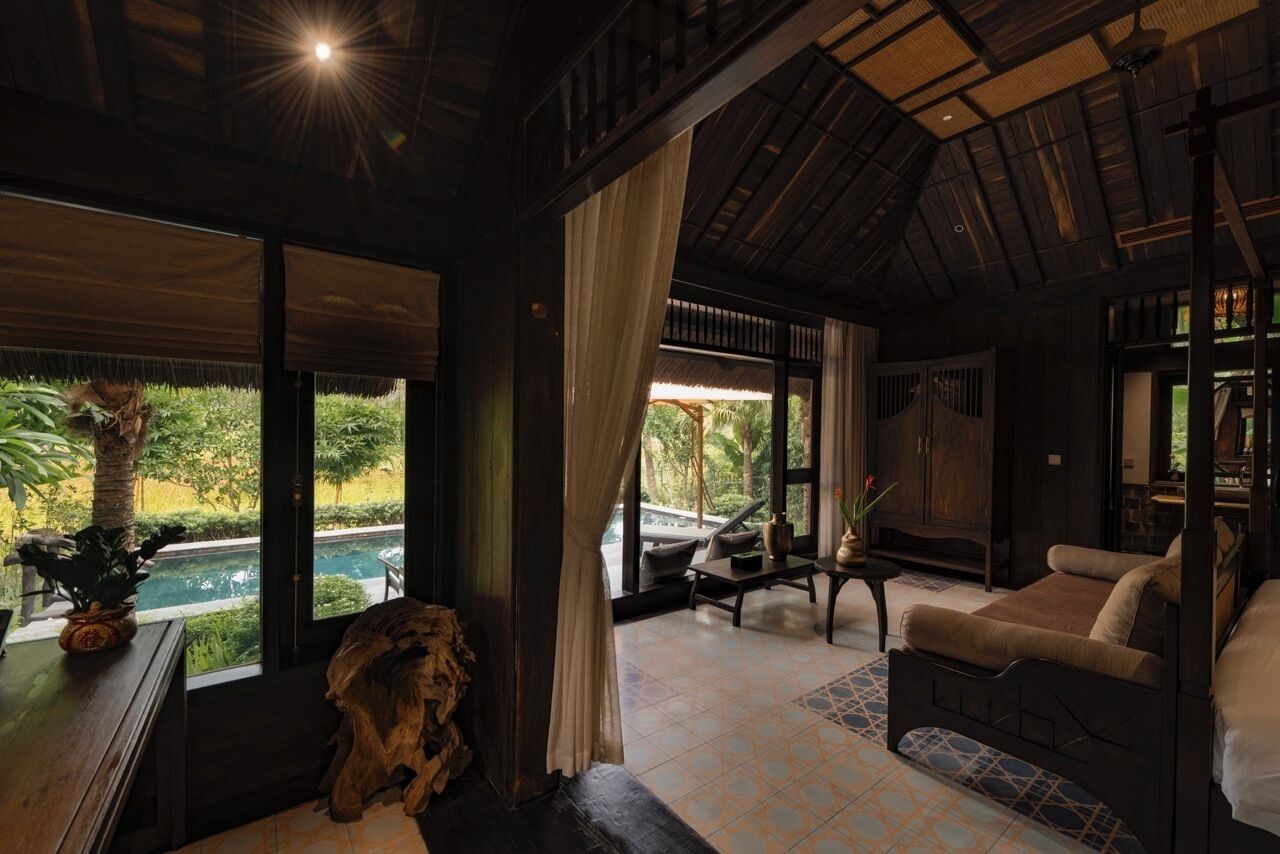 Una habitación con cama, una mesa, una silla y vista a una piscina.