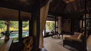 Una habitación con cama, una mesa, una silla y vista a una piscina.
