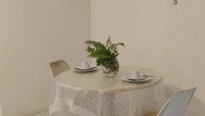 A dining area with a round table, chairs, and a potted plant. - Chale Zafira (Tibau do Sul)