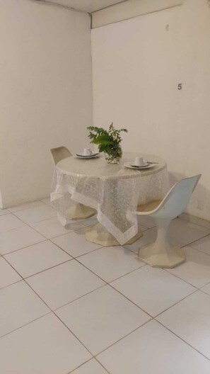 A dining area with a round table, chairs, and a potted plant. - Chale Zafira (Tibau do Sul)