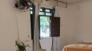 A room with a bed, a table with a plant, and a fan. - Chale Zafira (Tibau do Sul)