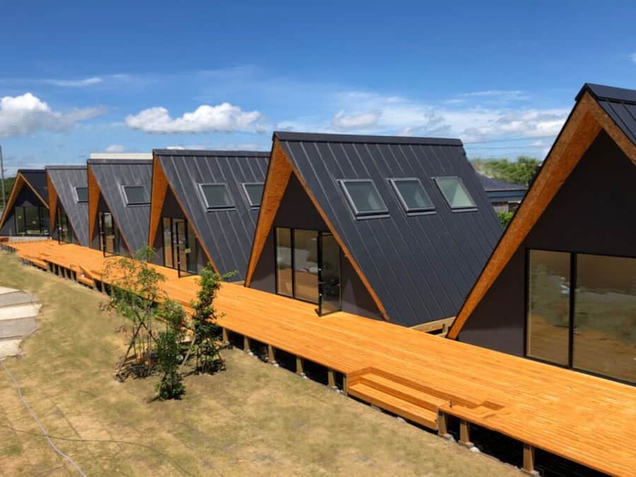 A row of modern, triangular-roofed cabins with large windows and wooden decks.