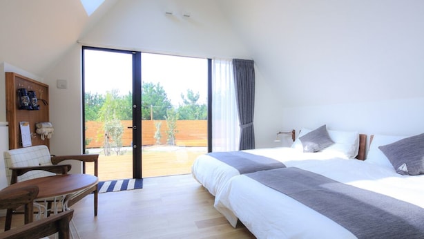 Un dormitorio con una cama grande, un escritorio y vistas al exterior.