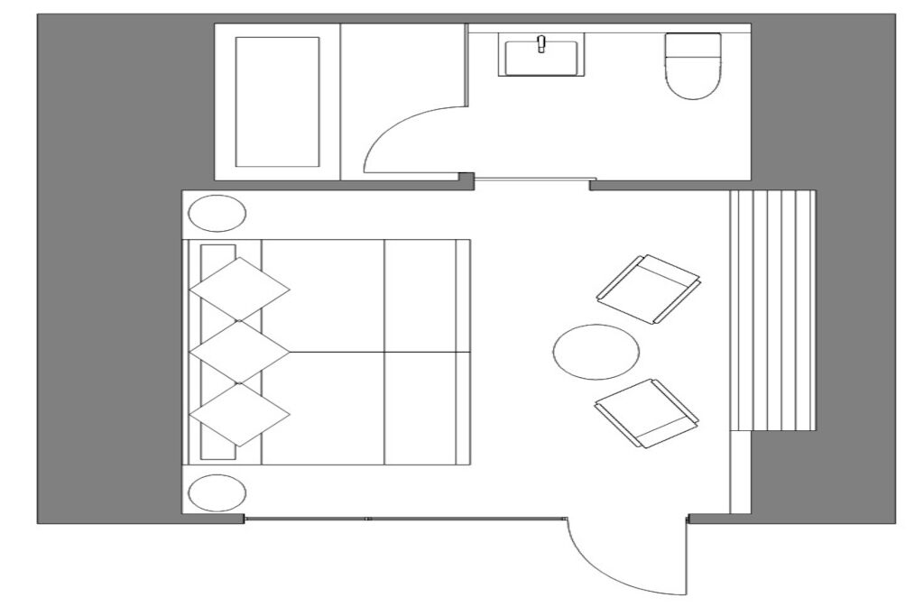 Ein Hotelzimmer mit Bett, Schreibtisch, Stuhl, kleinem Tisch und einer Couch.