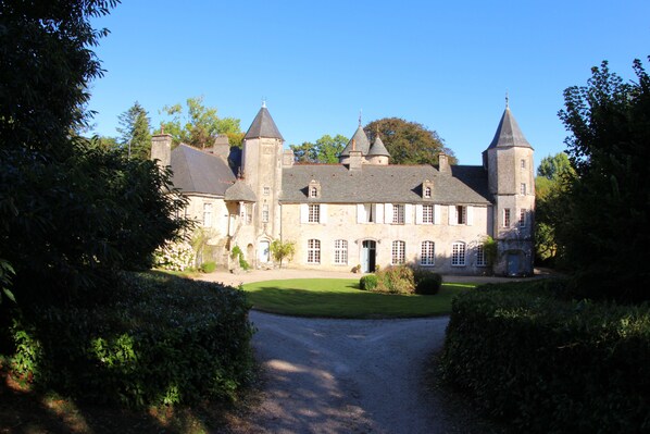 Un grand bâtiment en pierre, doté de nombreuses tours et d’une cour intérieure.