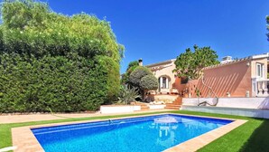A rectangular swimming pool with a tiled edge, surrounded by well-maintained grass and a variety of shrubs and trees. - VILLA JAVEA - TOSCAL (Javea)
