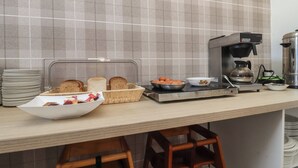 Eine Küche mit Kaffeemaschine, Toaster, Obstschale und einem Brotkorb.