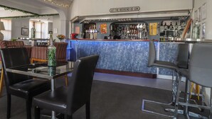 A bar area with a counter, bar stools, and a sign that reads 'LET THE WEEKEND BE-GIN'. - Luxury Winter Gardens Apartment 2 (Blackpool)