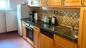 A kitchen with wooden cabinets, a dishwasher, a coffee maker, and a toaster.