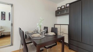 Ein Essbereich mit einem dunklen Holztisch, Stühlen und einem Spiegel.