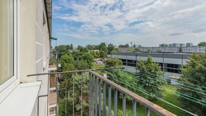 Ein Balkon mit Blick auf ein Wohngebiet, einschließlich Gebäude und Grünflächen.